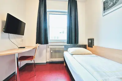 Ein Bett oder Betten in einem Zimmer der Unterkunft DJH Jugendgästehaus Adolph Kolping