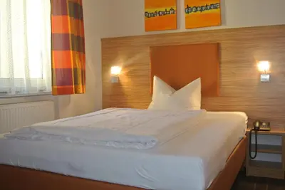 Ein Bett oder Betten in einem Zimmer der Unterkunft Hotel Art-Ambiente