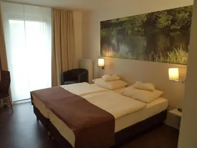 Ein Bett oder Betten in einem Zimmer der Unterkunft Das Neue Hotel Am Park