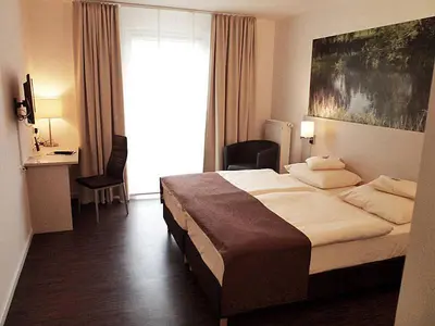 Ein Bett oder Betten in einem Zimmer der Unterkunft Das Neue Hotel Am Park